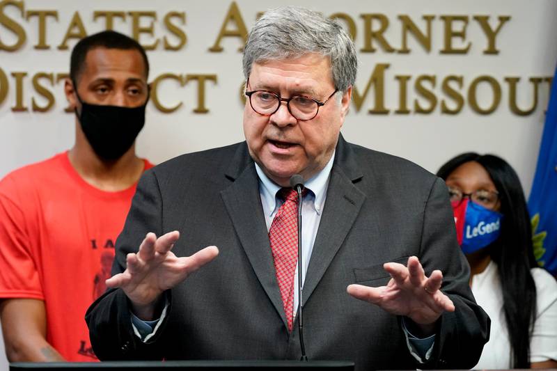 Attorney General William Barr talks to the media during a news conference about Operation Legend, a federal task force formed to fight violent crime in several cities, Wednesday, Aug. 19, 2020, in Kansas City, Mo. Behind Barr is Raphael Taliferro, and Charron Powell, the parents of 4-year-old LeGend Taliferro who was shot and killed while asleep in his bed and became the namesake for Operation Legend. (AP Photo/Charlie Riedel)