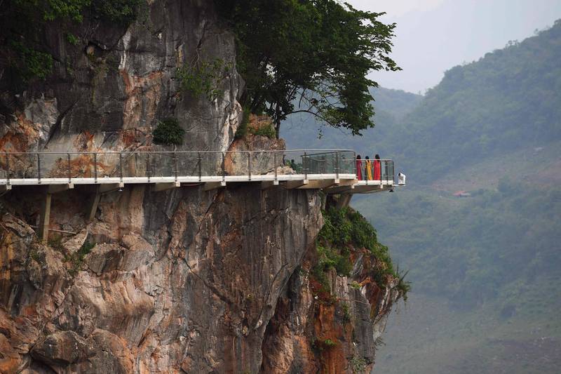 The bridge is suspended above a lush, jungle-clad gorge.