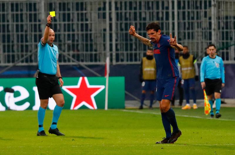 Atletico Madrid's Stefan Savic is shown a yellow card. Reuters