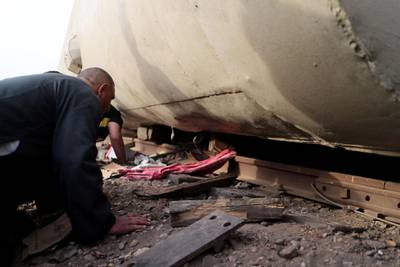 People inspect the damage at the site where train carriages derailed in Qalioubia province, north of Cairo, Egypt. Reuters