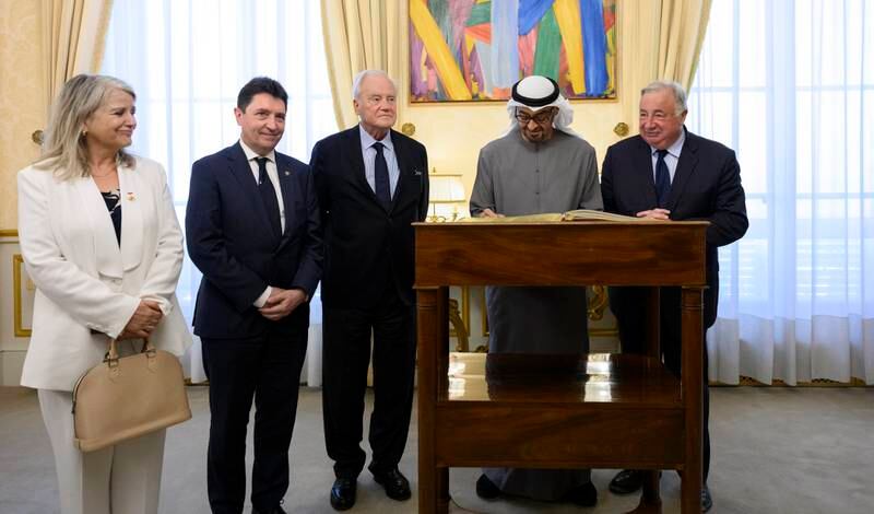 Sheikh Mohamed signs a guest book at the Luxembourg Palace. Seen with Mr Larcher. Photo: Presidential Court