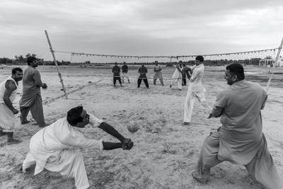 ABU DHABI, UNITED ARAB EMIRATES. 10 JANUARY 2020. Farm workers and laborers from Pakistan and India play an informal game of volleyball on a desolate patch of sand next to the Sheikh Mohammed Bin Rashid highway halfway between the Dubai and Abu Dhabi highway. (Photo: Antonie Robertson/The National) Journalist: STANDALONE. Section: Weekend.
