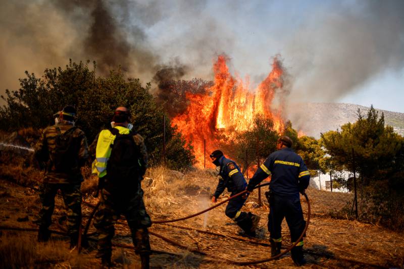 Firefighters and volunteers try to extinguish a blaze in the village of Markati, near Athens, Greece.