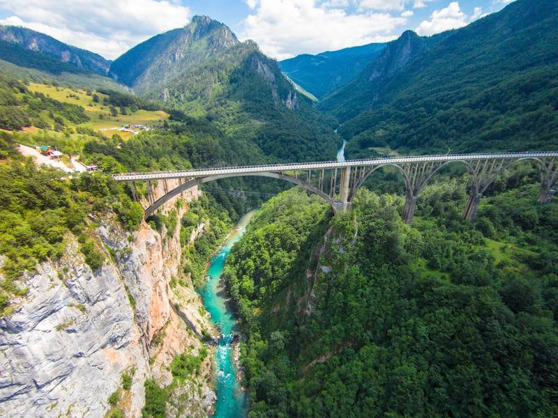 A bridge over the piercing blue River Tara which snakes between Montenegro and Bosnia and Herzegovina