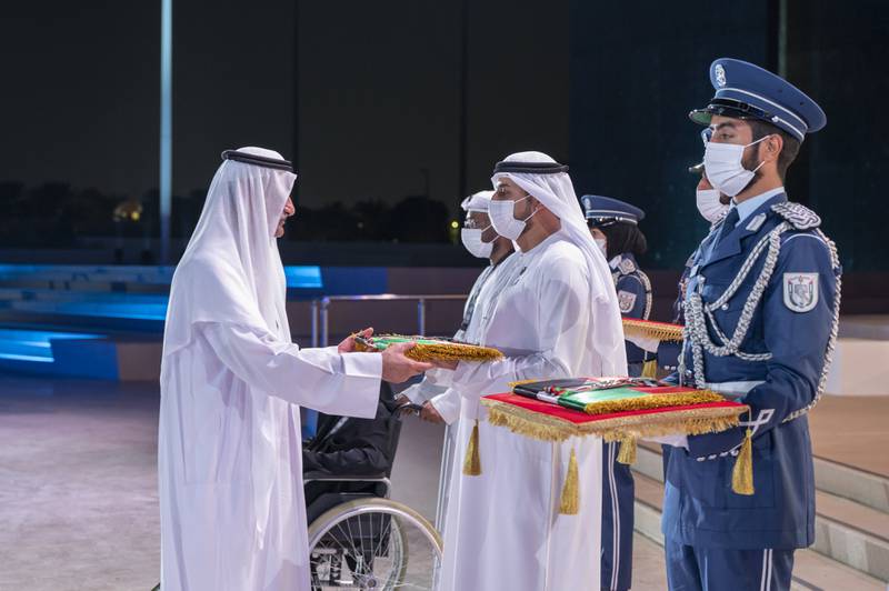 Sheikh Hamad bin Mohammed Al Sharqi, Ruler of Fujairah, presents a medal to a family member of a hero who passed away this year, during the Commemoration Day ceremony. Photo: Mohamed Al Hammadi / Ministry of Presidential Affairs