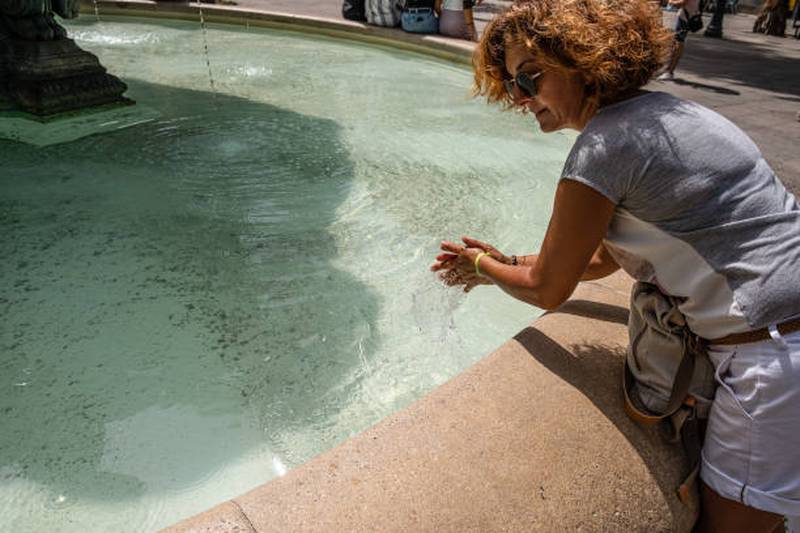 A woman refreshes herself during Barcelona's intense summer but more trees could help cool her and others down, the study found. Getty
