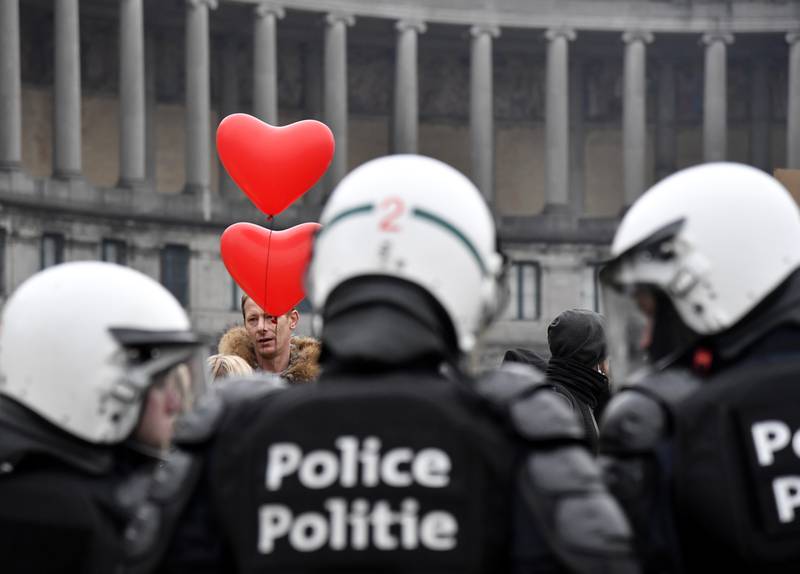 A man stands with red heart balloons near a police line during the demonstration. The protest was against measures including a vaccine pass regulating access to certain places and activities and possible compulsory vaccines. AP