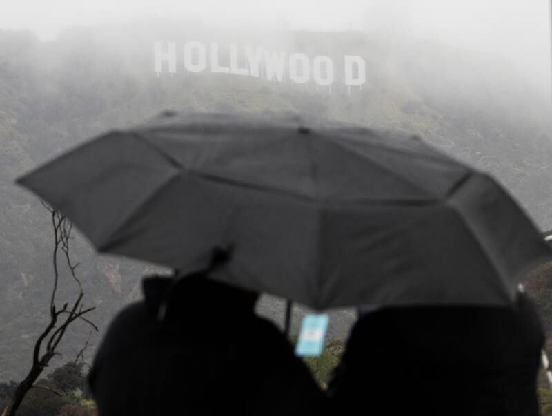 People look at the Hollywood sign during a rare winter storm in the Los Angeles area of California. Reuters