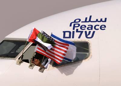 TOPSHOT - The Emirati, Israeli and US flags are picture attached to an air-plane of Israel's El Al, adorned with the word "peace" in Arabic, English and Hebrew, upon it's arrival at the Abu Dhabi airport in the first-ever commercial flight from Israel to the UAE, on August 31, 2020. A US-Israeli delegation including White House advisor Jared Kushner took off on a historic first direct commercial flight from Tel Aviv to Abu Dhabi to mark the normalisation of ties between the Jewish state and the UAE. / AFP / KARIM SAHIB
