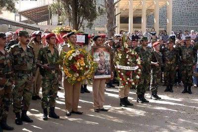A handout photo released by the official Syrian Arab News Agency SANA shows Syrian policemen holding wreaths and carrying coffins of their comrades during a funeral procession in southern Syria on Friday.