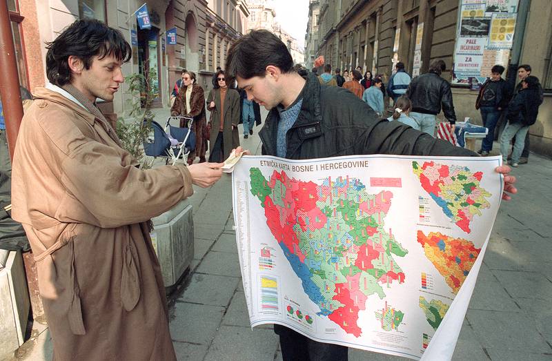 A street seller holds a map showing the ethnic distribution of Bosnia-Herzegovina on March 1, 1992 amid a state-wide vote on independence. AFP