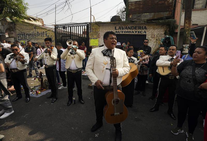 A mariachi group plays music outside the altar of Nuestra Senora de la Santa Muerte, or Our Lady of Holy Death, in Mexico City's Tepito neighborhood. La Santa Muerte is a folk saint, a personification of death, associated with healing, protection, and safe delivery to the afterlife by her devotees. AP Photo