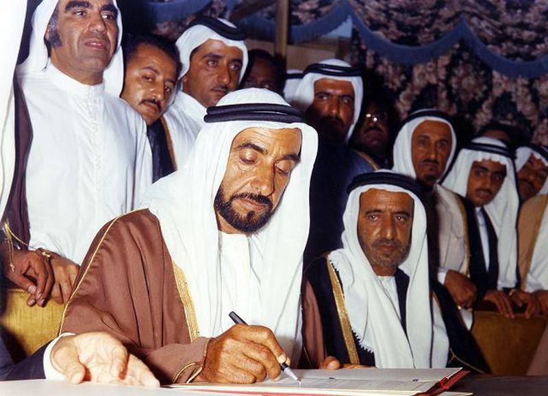 Sheikh Zayed signs the Federation Agreement on December 2, 1971, creating the UAE. On his left is Sheikh Rashid, then Ruler of Dubai. Behind them are Mehdi Al Tajir, Sheikh Maktoum bin Rashid and Sheikh Hamdan bin Rashid.