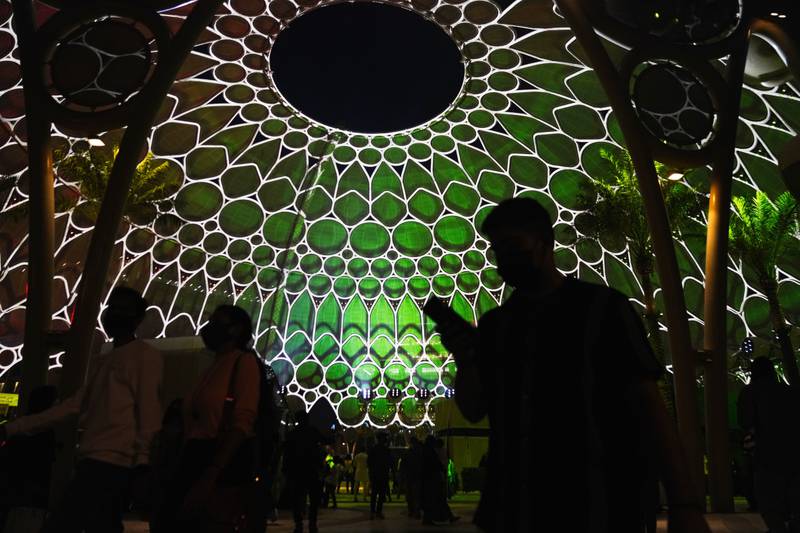 Expo visitors are silhouetted by the lights on the Al Wasl Plaza dome. AP Photo