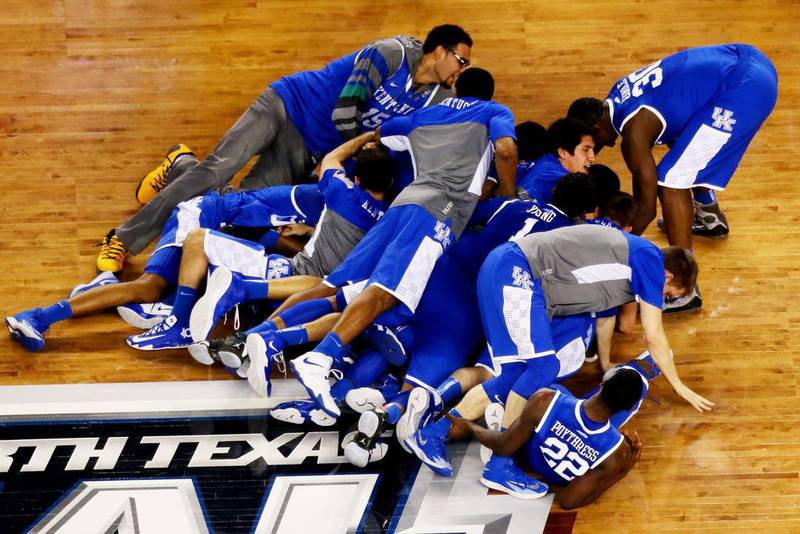 The Kentucky Wildcats celebrate after defeating the Wisconsin Badgers to advance to the NCAA men's basketball national title game on Saturday. Ronald Martinez / Getty Images / AFP / April 5, 2014