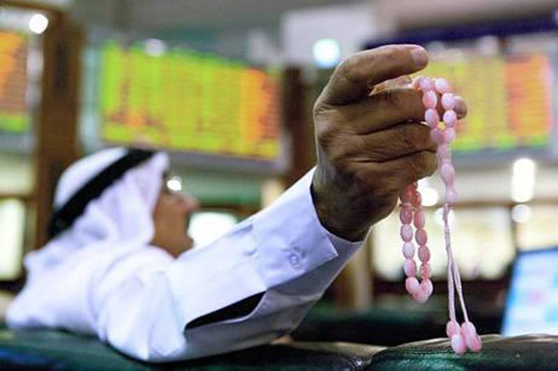 FILE PHOTO / BEST BLOOMBERG PHOTOS FOR 2011: A visitor holds prayer beads as he watches financial data on screens inside the Dubai Financial Market in Dubai, United Arab Emirates, on Monday, Aug. 8, 2011. Dubai's stock index retreated to the lowest since March as global financial markets slumped amid concern that Standard & Poor's downgrading of the U.S.'s credit rating may stall the global economic recovery. Photographer: Duncan Chard/Bloomberg *** Local Caption ***  946467.jpg