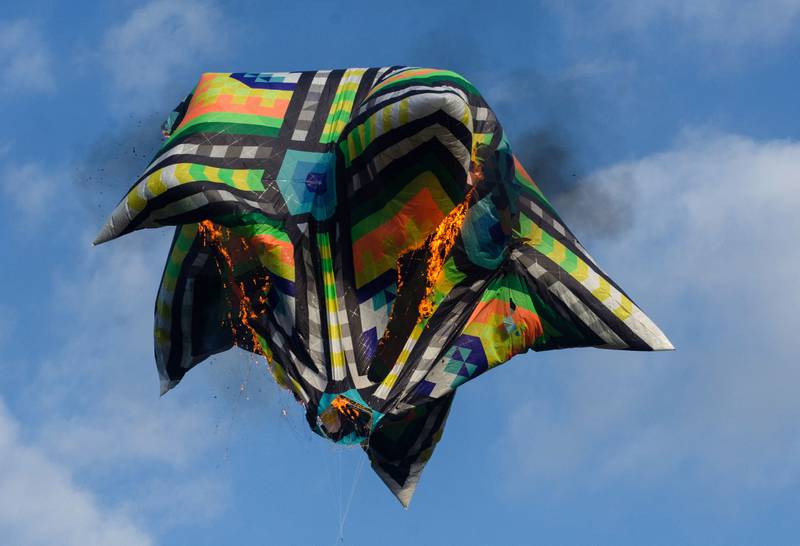 A hot air balloon burns and falls to the ground on Mother's Day in Rio de Janeiro. The balloon had no passengers. AFP

