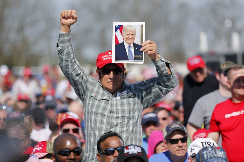 A Trump supporter at Saturday's rally holds up an image of the former US president. AP