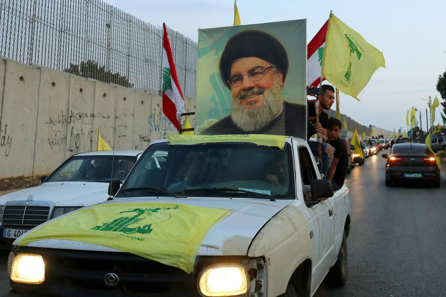 FILE PHOTO: Supporters of Lebanon's Hezbollah leader, Sayyed Hassan Nasrallah, ride in a vehicle decorated with Hezbollah and Lebanese flags and a picture of him, as part of a convoy in the southern village of Kfar Kila, Lebanon October 25, 2019. REUTERS/Aziz Taher/File Photo