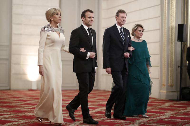Brigitte, wearing a white silk Louis Vuitton gown with an embellished shoulder, with Emmanuel Macron, Grand Duke of Luxembourg Henri and his wife Maria Teresa, on March 19, 2018. AFP