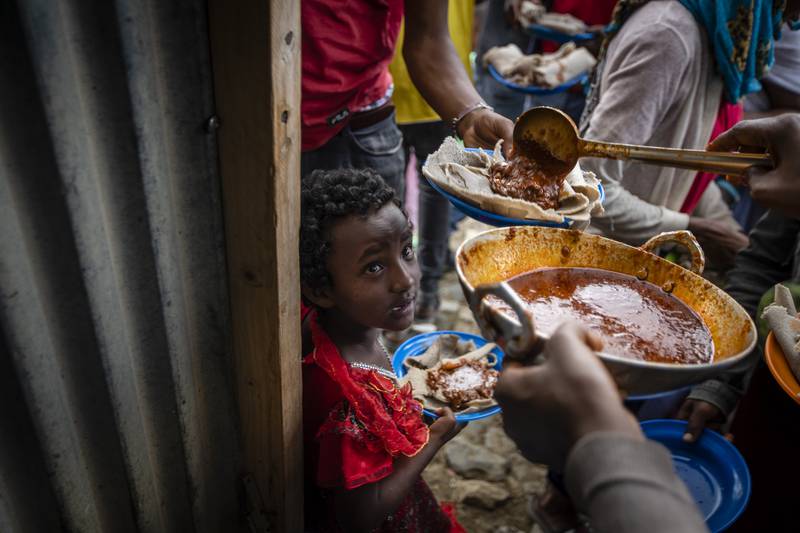 Elena, 7, centre, lines up with other displaced Tigrayans to receive food at a centre for the internally displaced in Mekele, in the Tigray region of northern Ethiopia. Ben Curtis / AP Photo