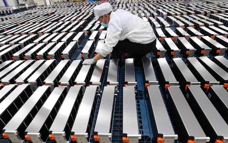 A worker with electric car batteries at a factory in China. AFP