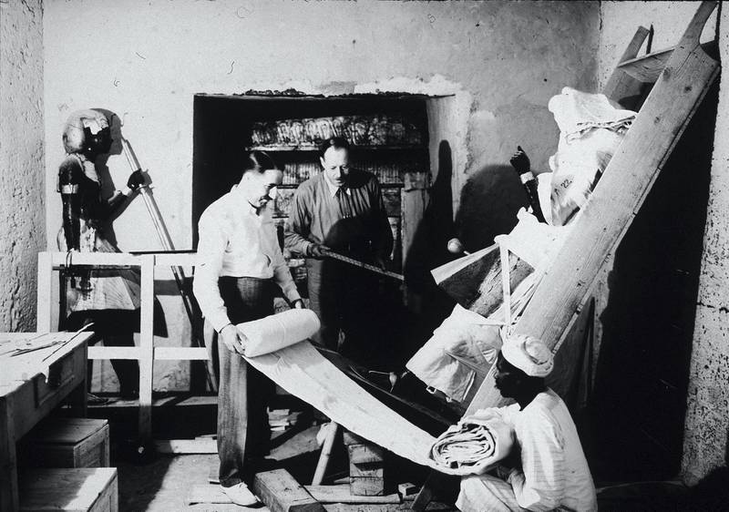 British archaeologists Howard Carter (1874 - 1939) (left) and Arthur Callender (died 1937) carry out the systematic removal of objects from the antechamber of the tomb of Pharaoh Tutankhamen, better known as King Tut, with the assistance of an Egyptian laborer, Valley of the Kings, Thebes, Egypt, 1923. (Photo by Hulton Archive/Getty Images)