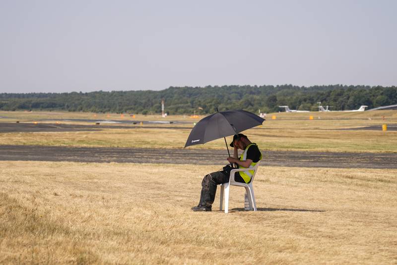 A member of staff shelters from the sun. AP