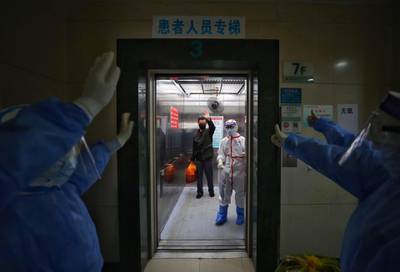 Medical staff wave goodbye to a recovered COVID-19 coronavirus patient at the Red Cross Hospital in Wuhan in China's central Hubei province.  AFP