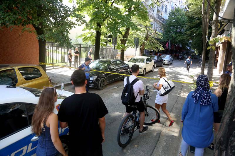 Bystanders look on as Albanian police forces secure the area around the Iranian embassy in Tirana. AFP