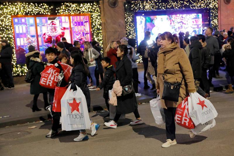 FILE PHOTO: People carry shopping bags from Macy's Herald Square during early opening for the Black Friday sales in Manhattan, New York City, U.S., November 28, 2019. REUTERS/Andrew Kelly/File Photo
