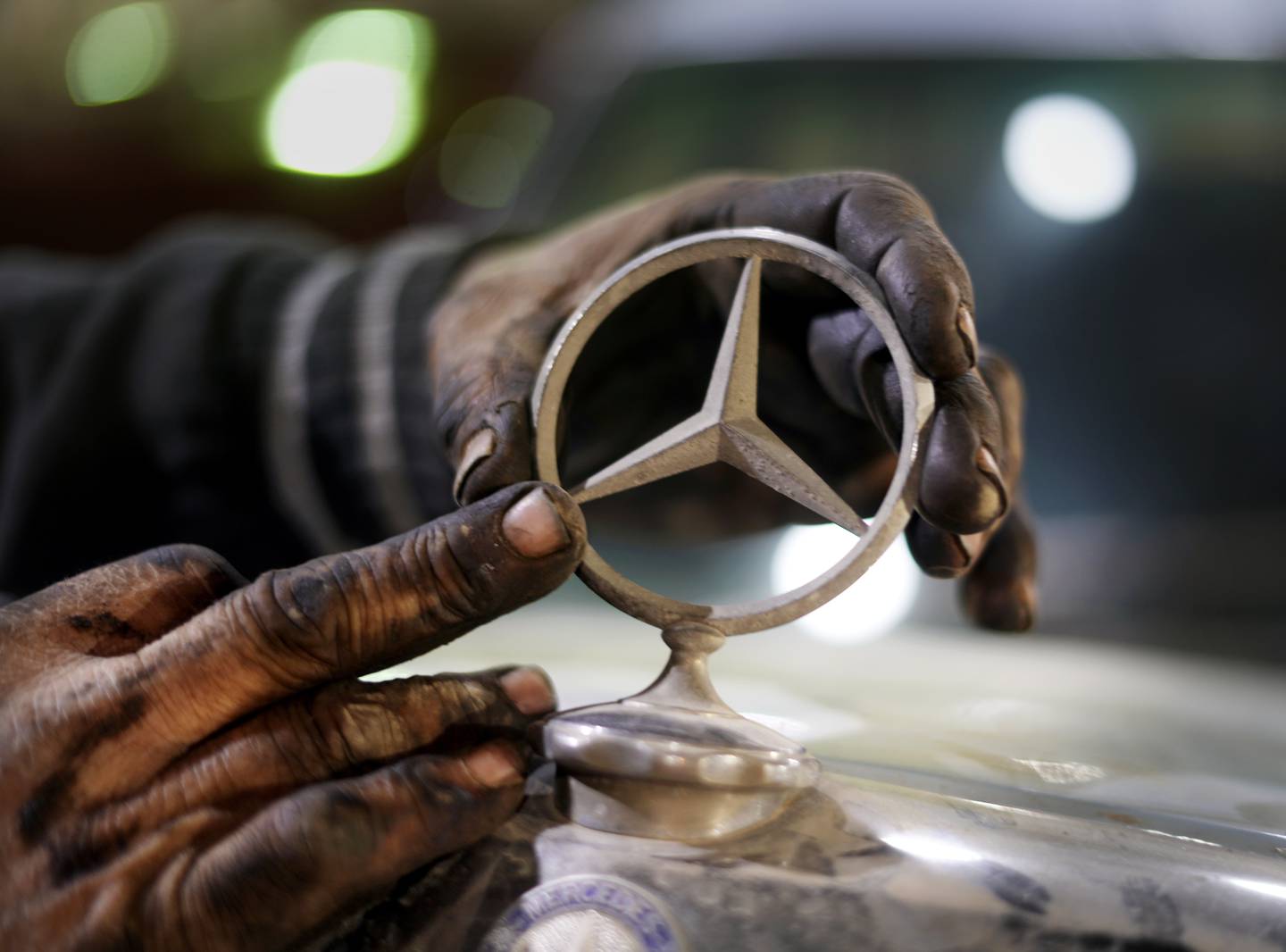 A mechanic replaces the bonnet ornament on a 1976 Mercedes at a private collector's lot in El Saff city outside Cairo, Egypt. AP Photo