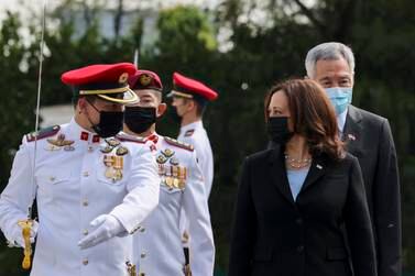 U. S.  Vice President Kamala Harris, front right, prepares to inspect an honor guard with Singapore's Prime Minister Lee Hsien Loong, rear right, at the Istana in Singapore Monday, Aug.  23, 2021.  (Evelyn Hockstein / Pool Photo via AP)