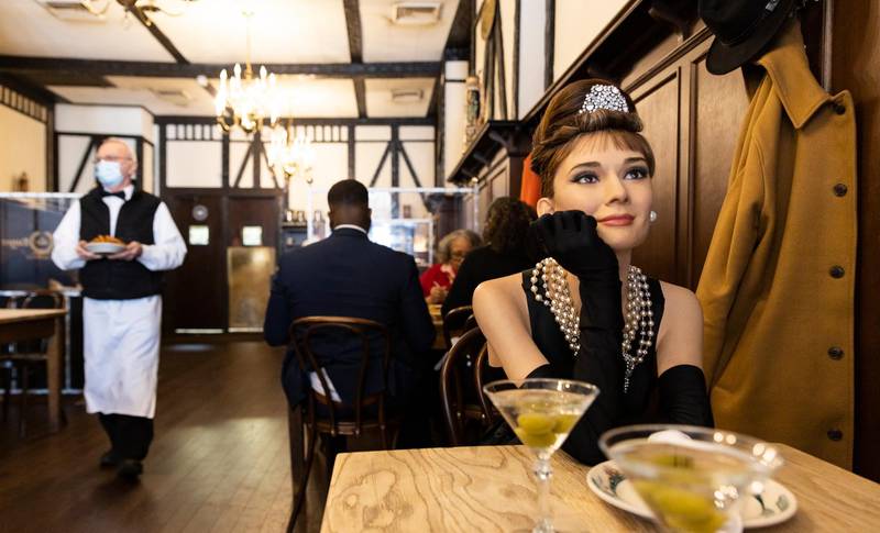 A wax figure of Audrey Hepburn sits at a table left empty to comply with Covid-19 social distancing requirements in a dining room at Peter Luger's Steak House in the Brooklyn borough of New York. EPA