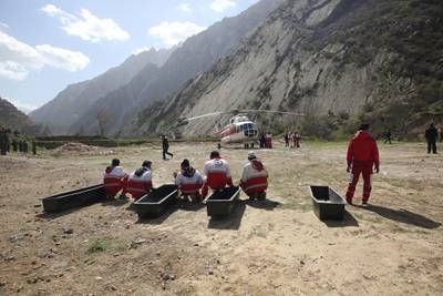 In this photo provided by the Iranian Labor News Agency, ILNA, rescue workers wait for the bodies of passengers from a Turkish private jet that crashed on Sunday in the Zagros Mountains, outside of the city of Shahr-e Kord, outside of the city of Shahr-e Kord, some 370 kilometers, or 230 miles, south of the capital, Tehran, Iran, Monday, March 12, 2018. Investigators on Monday found the "black box" from the jet that crashed on its way from the United Arab Emirates to Istanbul, killing all 11 people on board, including a Turkish bride-to-be and her bachelorette party. (Mostafa Safari/ILNA, via AP)