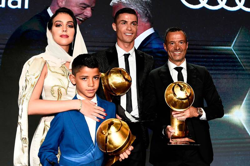 Cristiano Ronaldo (C), holding his "Best Player of the Year 2018 Award" and Portuguese football agent Jorge Mendes (R), holding his "Best Agent of the Year 2018 Award" pose with Ronaldo's companion Georgina Rodriguez (L) and Ronaldo's son Cristiano Jr. AFP