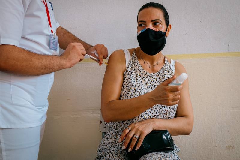 A nursing student administers the coronavirus vaccine at a high school in Sfax, Tunisia, during the country's open vaccine drive.