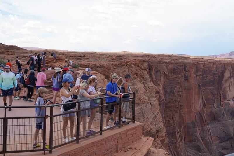 Tourists gather at Horseshoe Bend, a natural U-turn in the Colorado River.