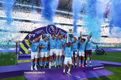 City's Ilkay Gundogan lifts the Premier League trophy as he celebrates with teammates. Reuters