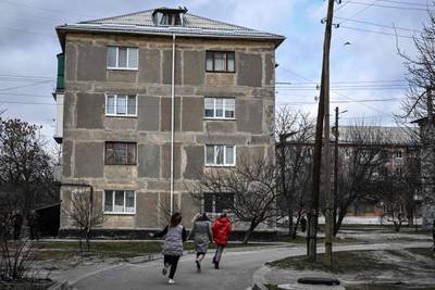 Three women run for cover during shelling in Schastia, eastern Ukraine. AFP