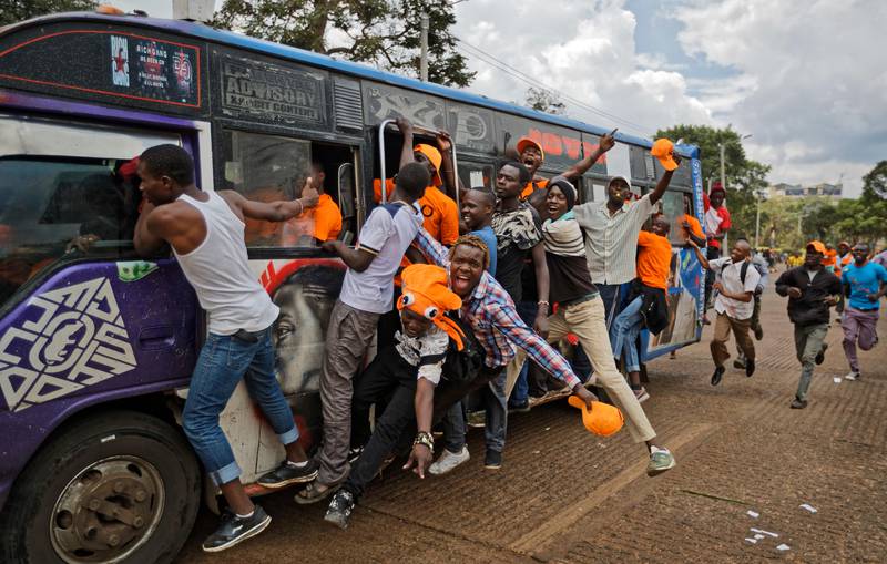 Supporters of opposition leader Raila Odinga ride on the outside of a "matatu" minibus as they arrive for a rally in Uhuru Park in downtown Nairobi, Kenya. Ben Curtis / AP Photo