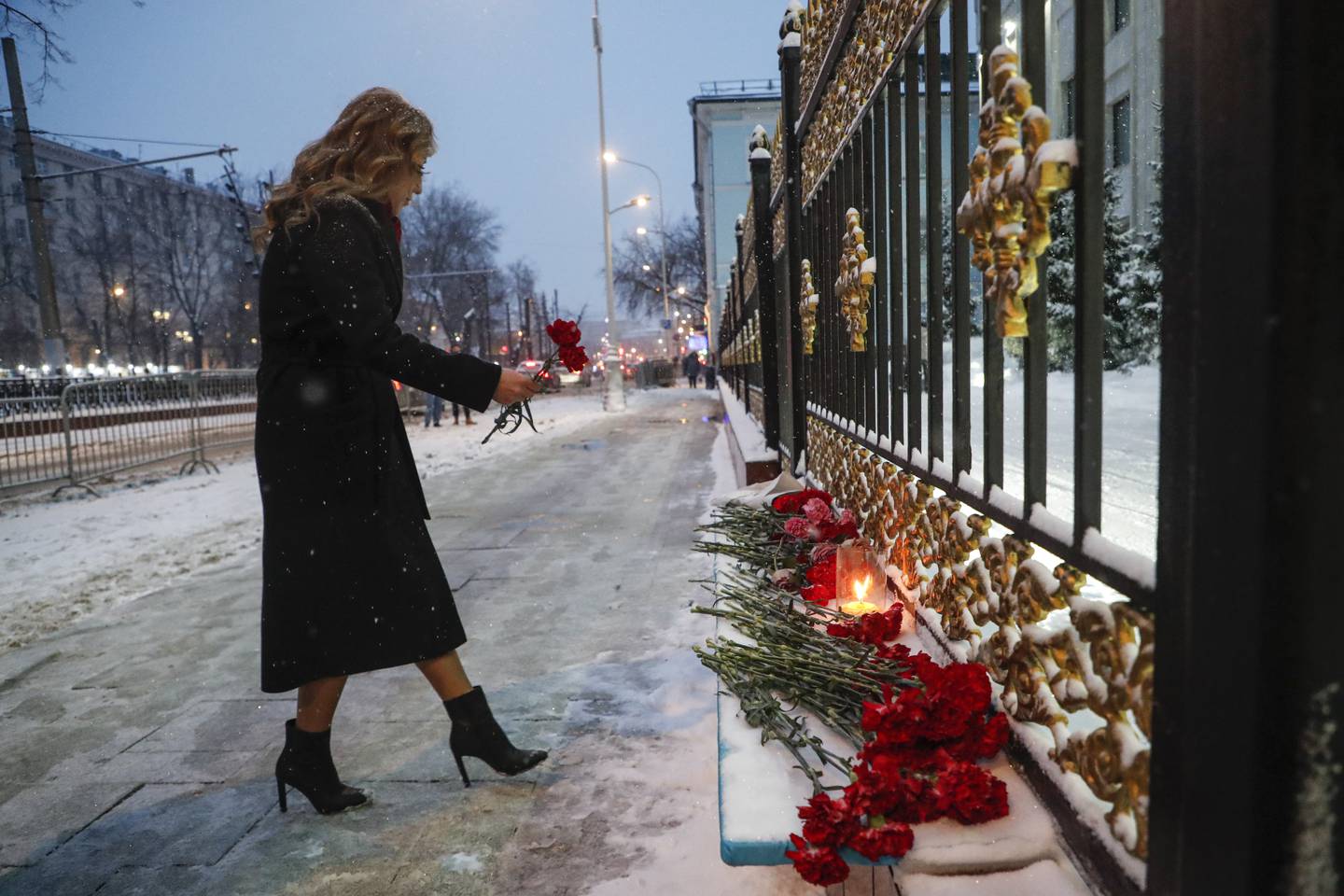 A woman places flowers at the entrance of the Kazakh embassy in Moscow, for the 164 people killed during the riots in Kazakhstan, in Russia, January 10. EPA