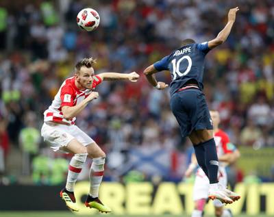 Mbappe and Croatia's Ivan Rakitic jump for the ball. AP