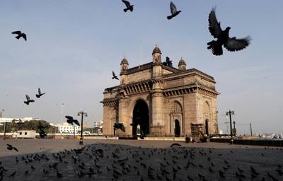 Pigeons fly at a deserted Gateway of India monument in Mumbai, India. AP Photo