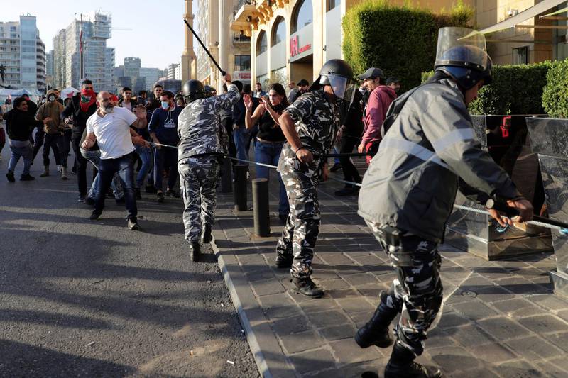 Riot police swing batons at anti-government protesters who try to remove barbed wire blocking a road to the parliament building during a protest in downtown Beirut. AP Photo