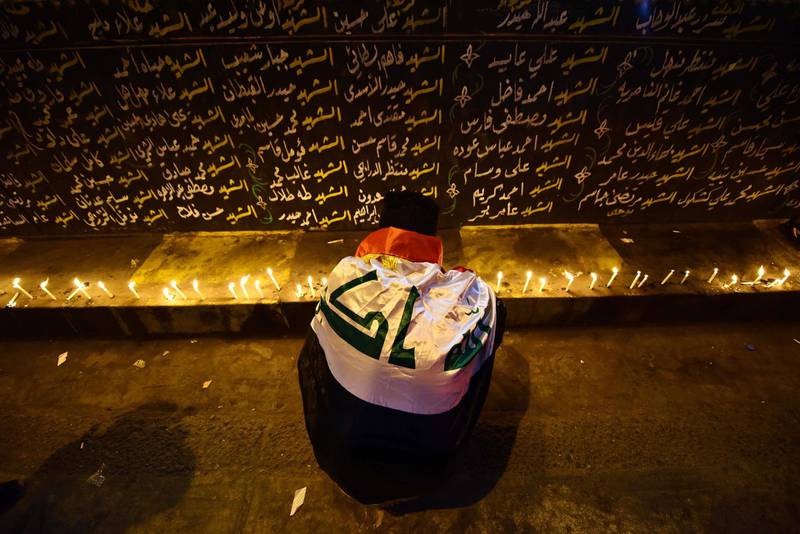A protester lights candles and prays for the victims of protests at Tahrir Square in central Baghdad. EPA