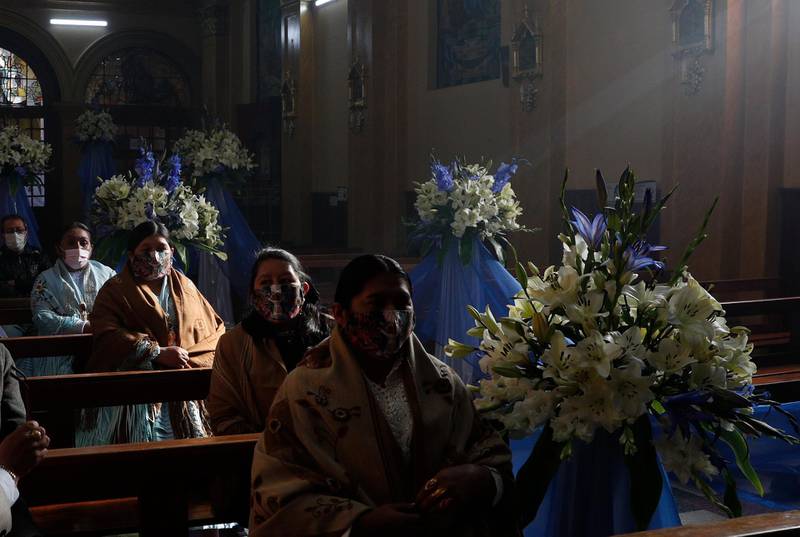 Devotees wearing face masks attend a mass in La Paz, Bolivia. AP Photo