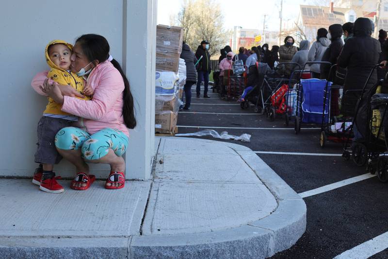 Elvia Garcia kisses her 2-year-old son Joshua while they wait with hundreds of other residents to pick up free groceries from the food pantry in Chelsea, Massachusetts, US. Reuters