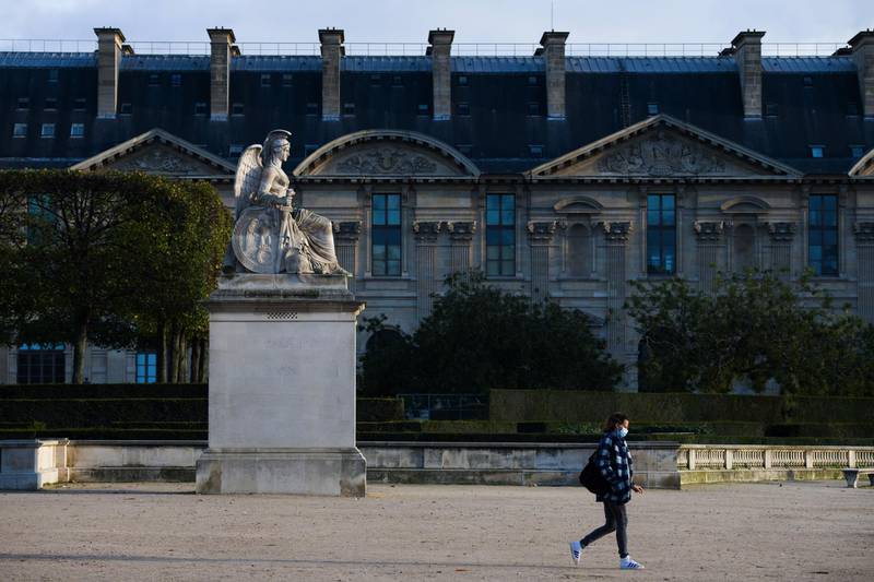 A pedestrian wearing a protective face mask passes the Louvre Museum in Paris. Bloomberg
