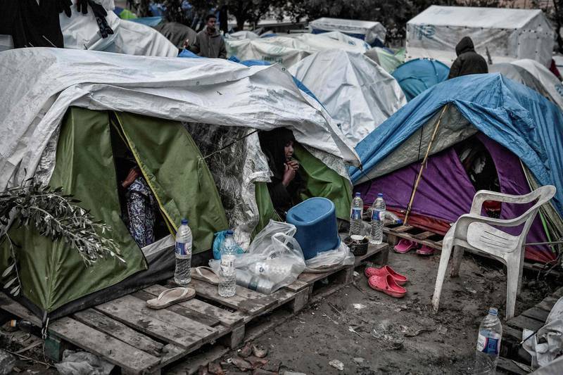 (FILES) In this file photo taken on December 10, 2019, a woman sit at the door of a tent in the Vial camp on the island of Chios which has only 1,000 places, but houses nearly 5,000 asylum seekers in unsanitary conditions and many camps  situated in the nearby olive groove are without toilets, bathrooms, electricity and water. A fire ripped through one of Greece's largest migrant camps leaving widespread damage and many people homeless after the death of an Iraqi woman sparked unrest, officials said on April 19, 2020. The blaze late April 18, at Vial camp on Chios island destroyed the facilities of the European asylum service, a camp canteen, warehouse tents and many housing containers, Migration Ministry Secretary Manos Logothetis told AFP.
 / AFP / LOUISA GOULIAMAKI
